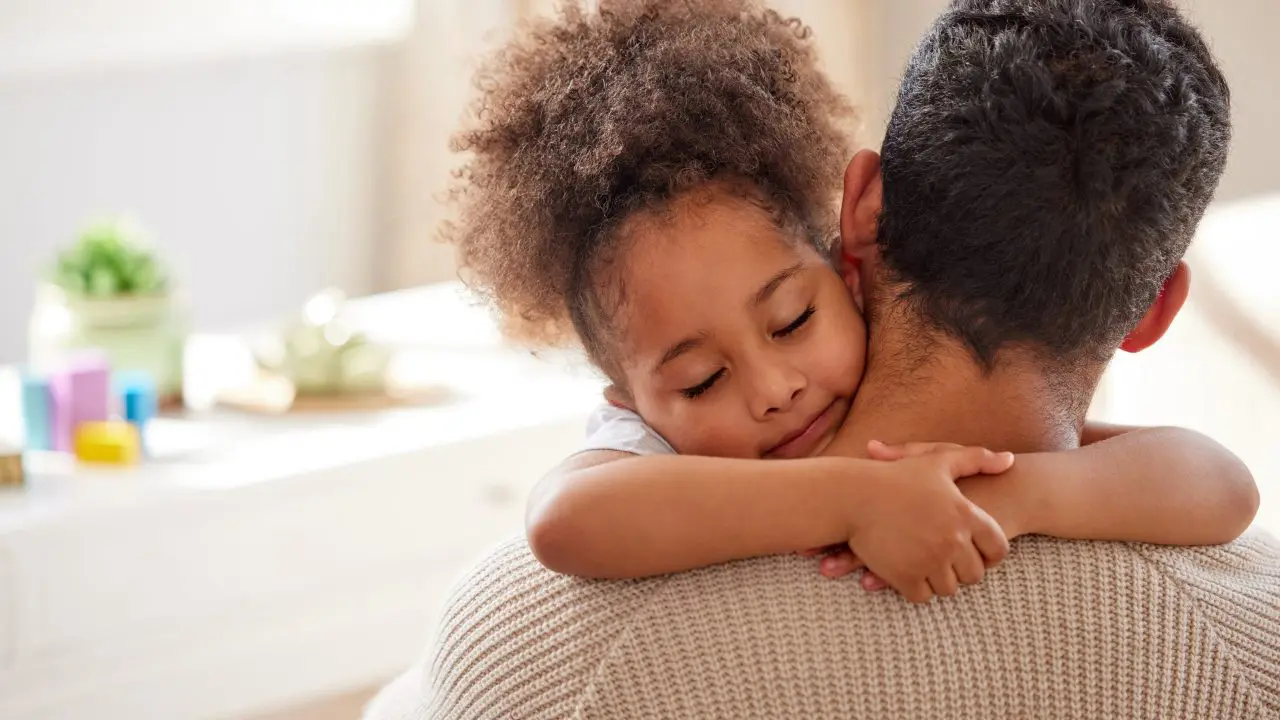 Young girl hugging parent