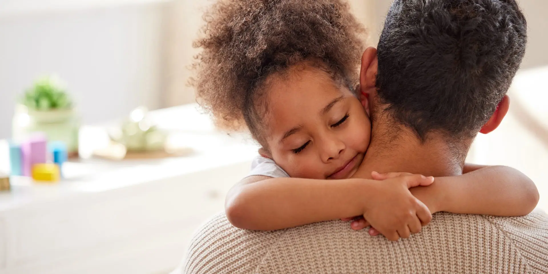Young girl hugging parent