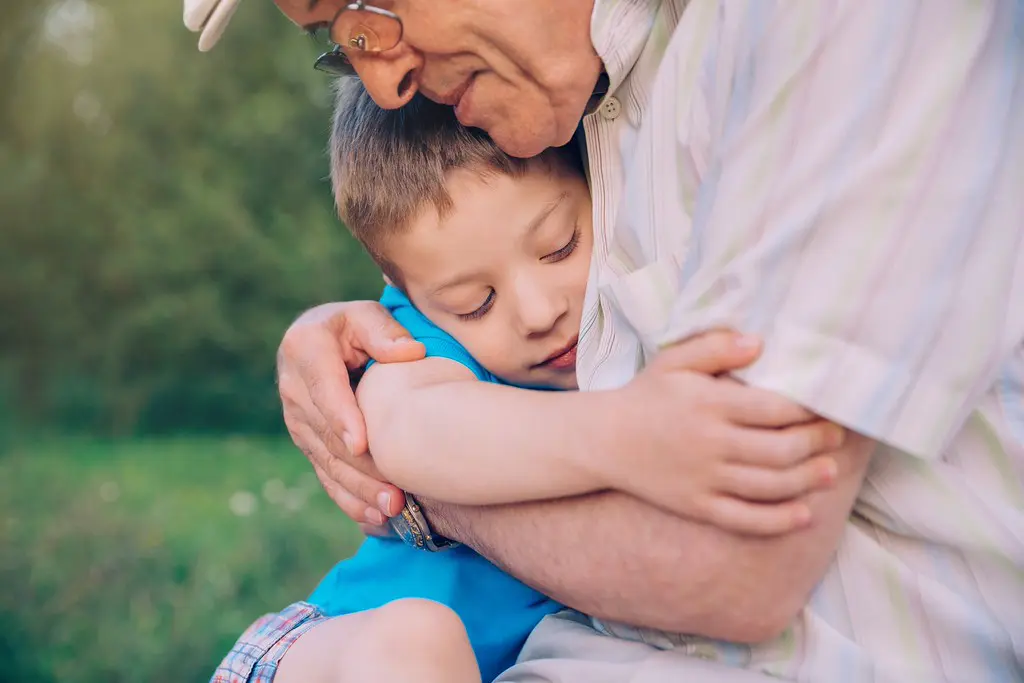 Young child hugging older dad