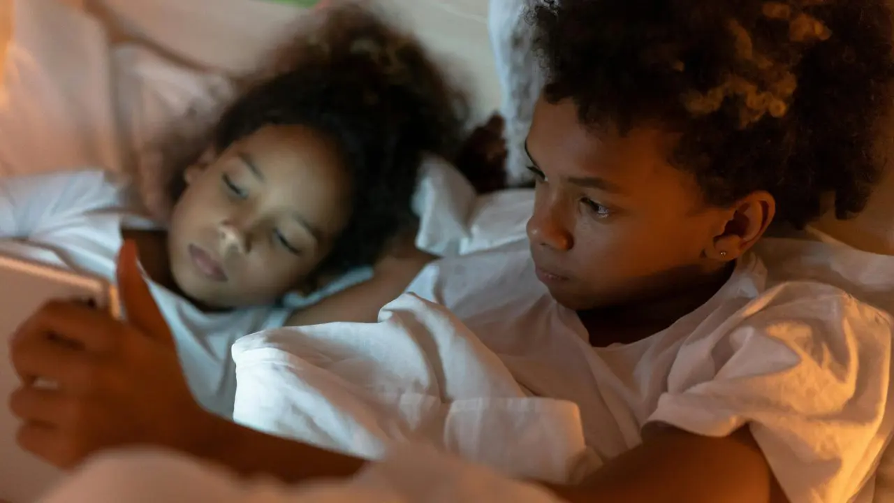 Young brother and sister sharing tablet device.
