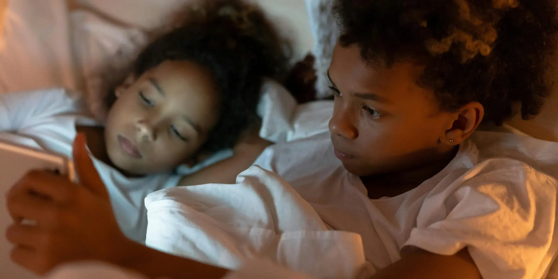 Young brother and sister sharing tablet device.