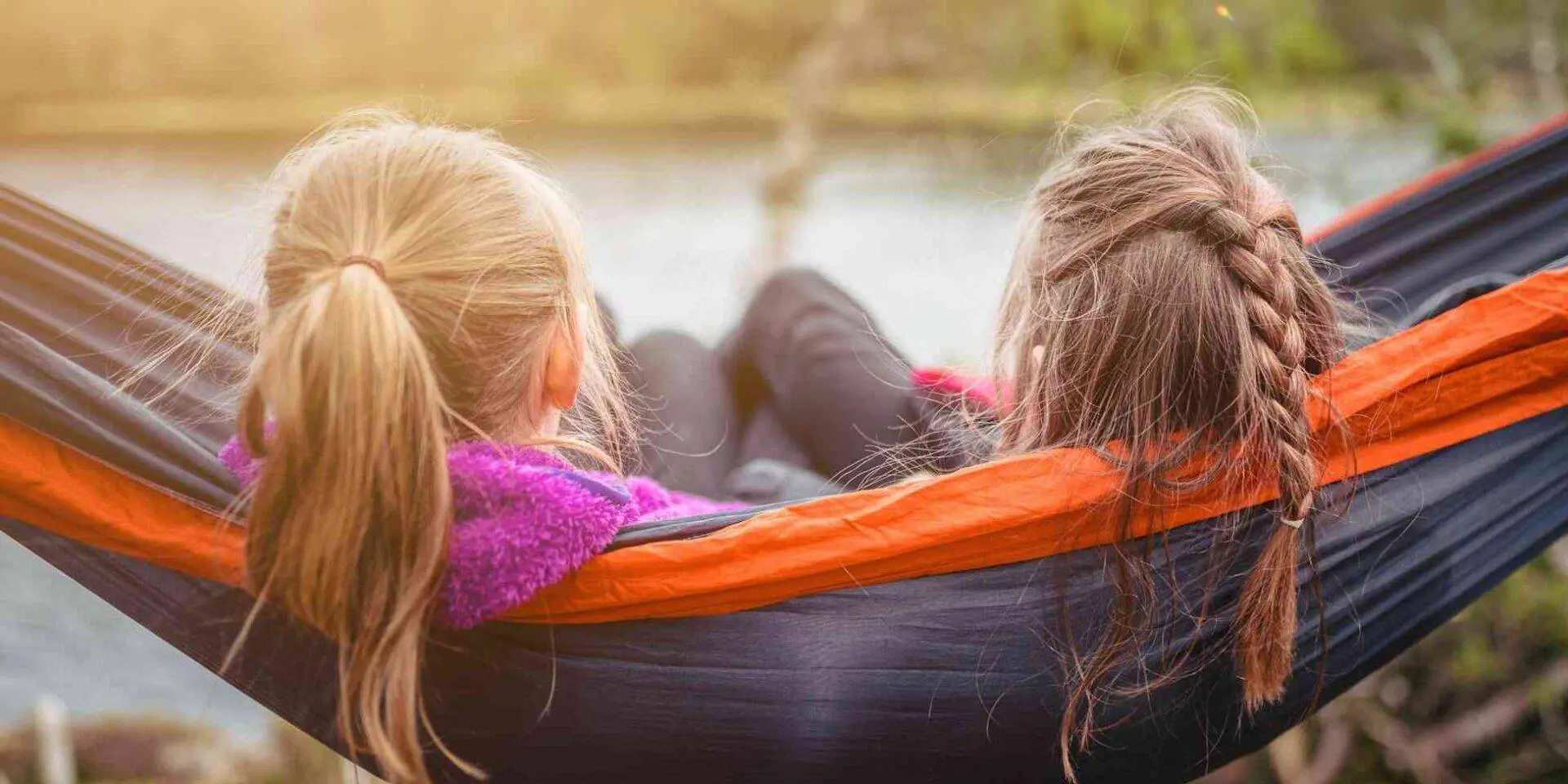 Two girls sitting on a hammock - manage grief over summer holidays - Photo by SI Janko Ferlic on Unsplash