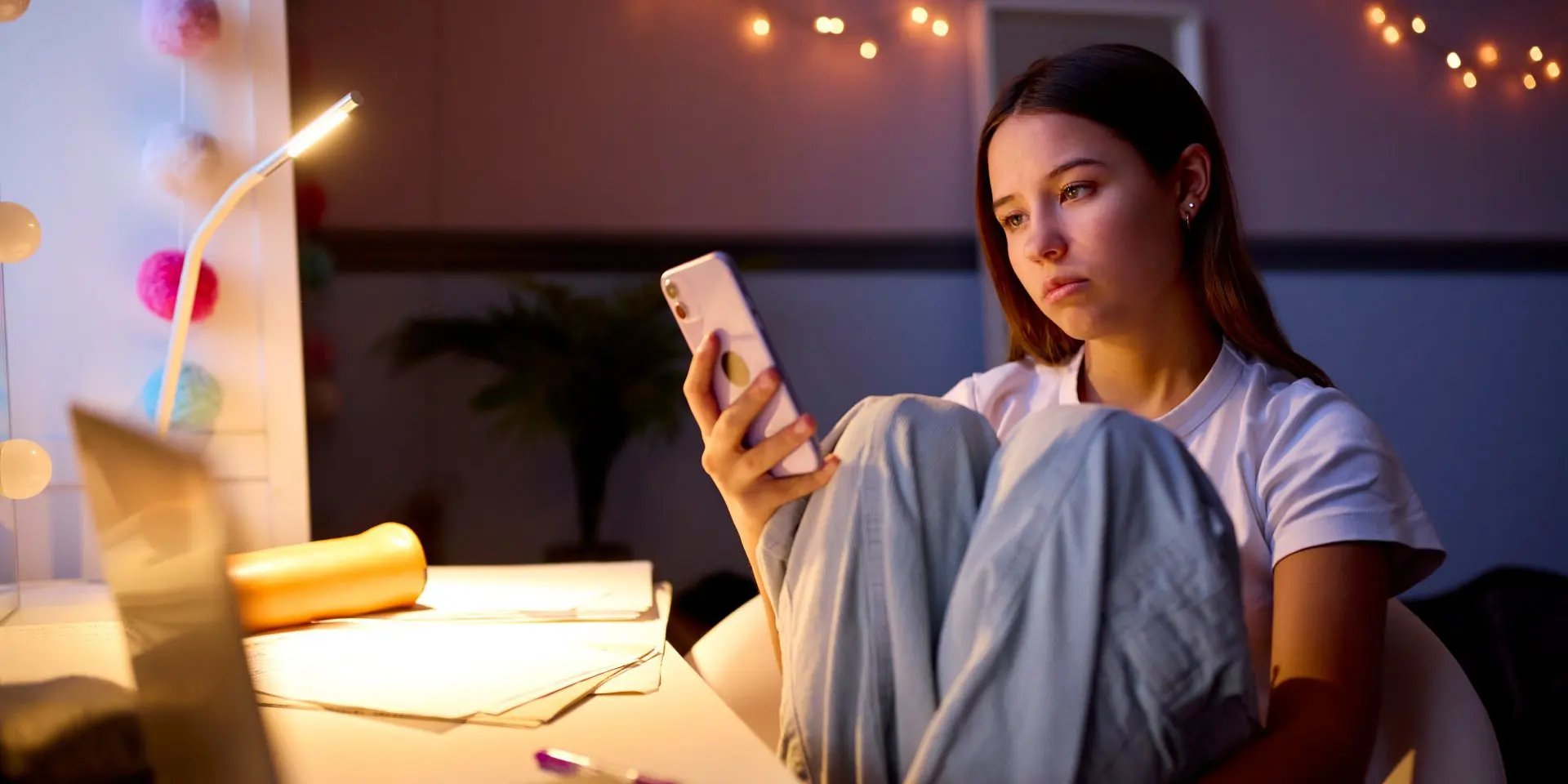 Teenage girl looking at her phone and looking sad