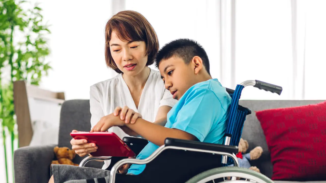 Parent using tablet device with child with SEND.