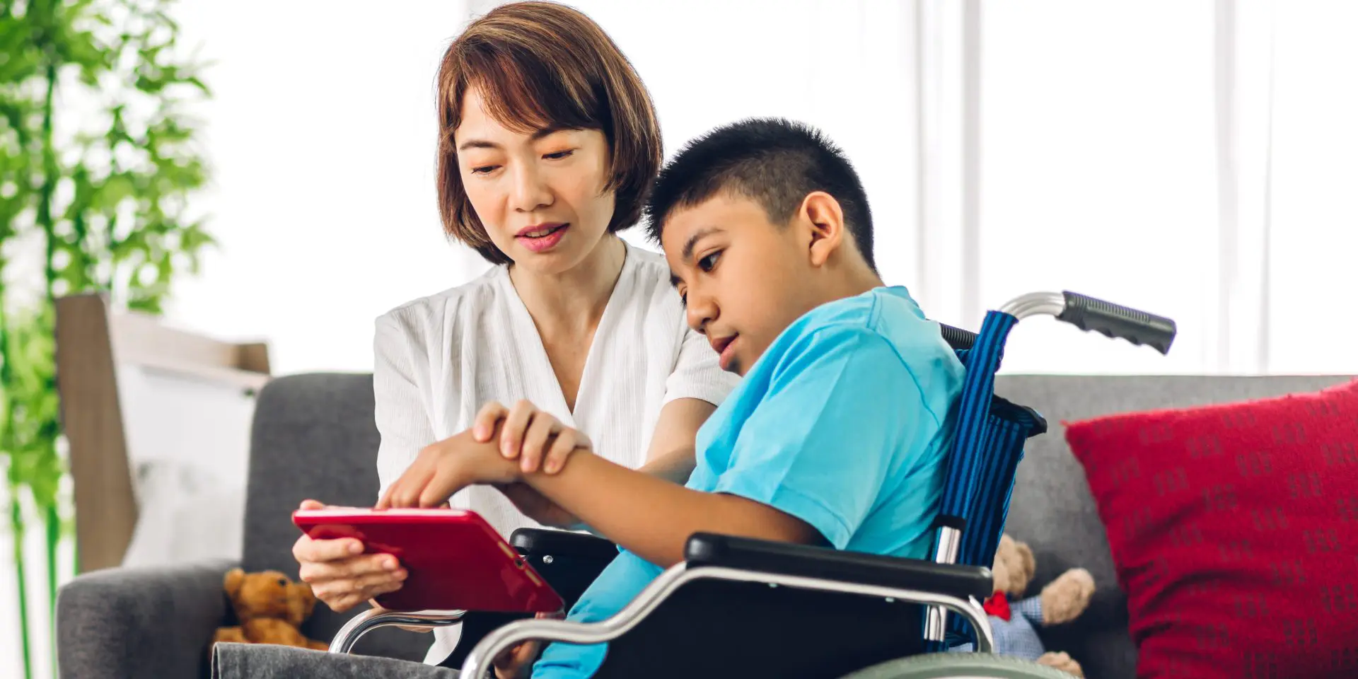 Parent using tablet device with child with SEND.