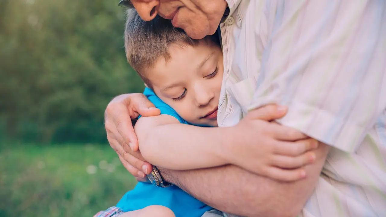 Young child hugging man.