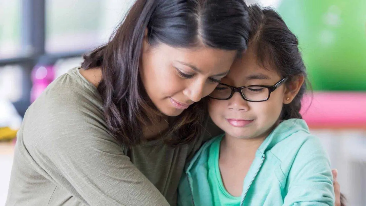 Young girl looking upset and being hugged by her mum - Supporting children after a baby dies - Winston's Wish