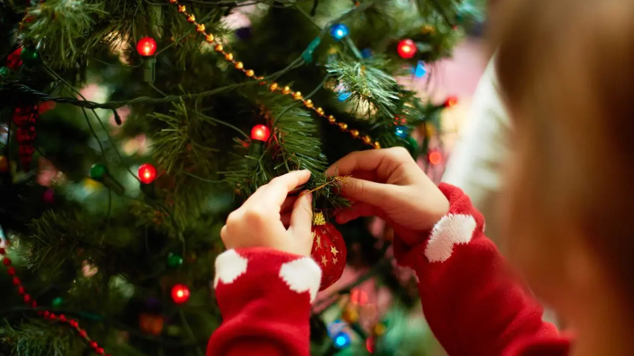 Child's hands putting decorations on a Christmas tree - Winston's Wish