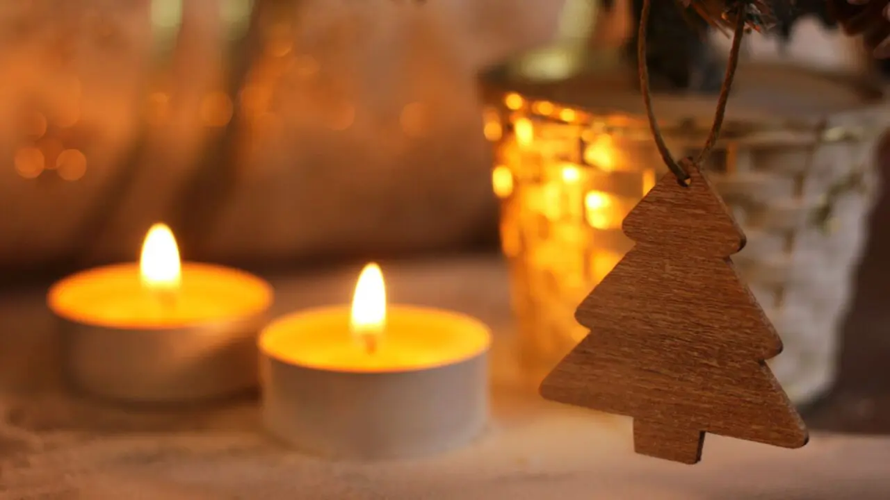 Two candles behind a tree shaped Christmas decoration - Winston's Wish