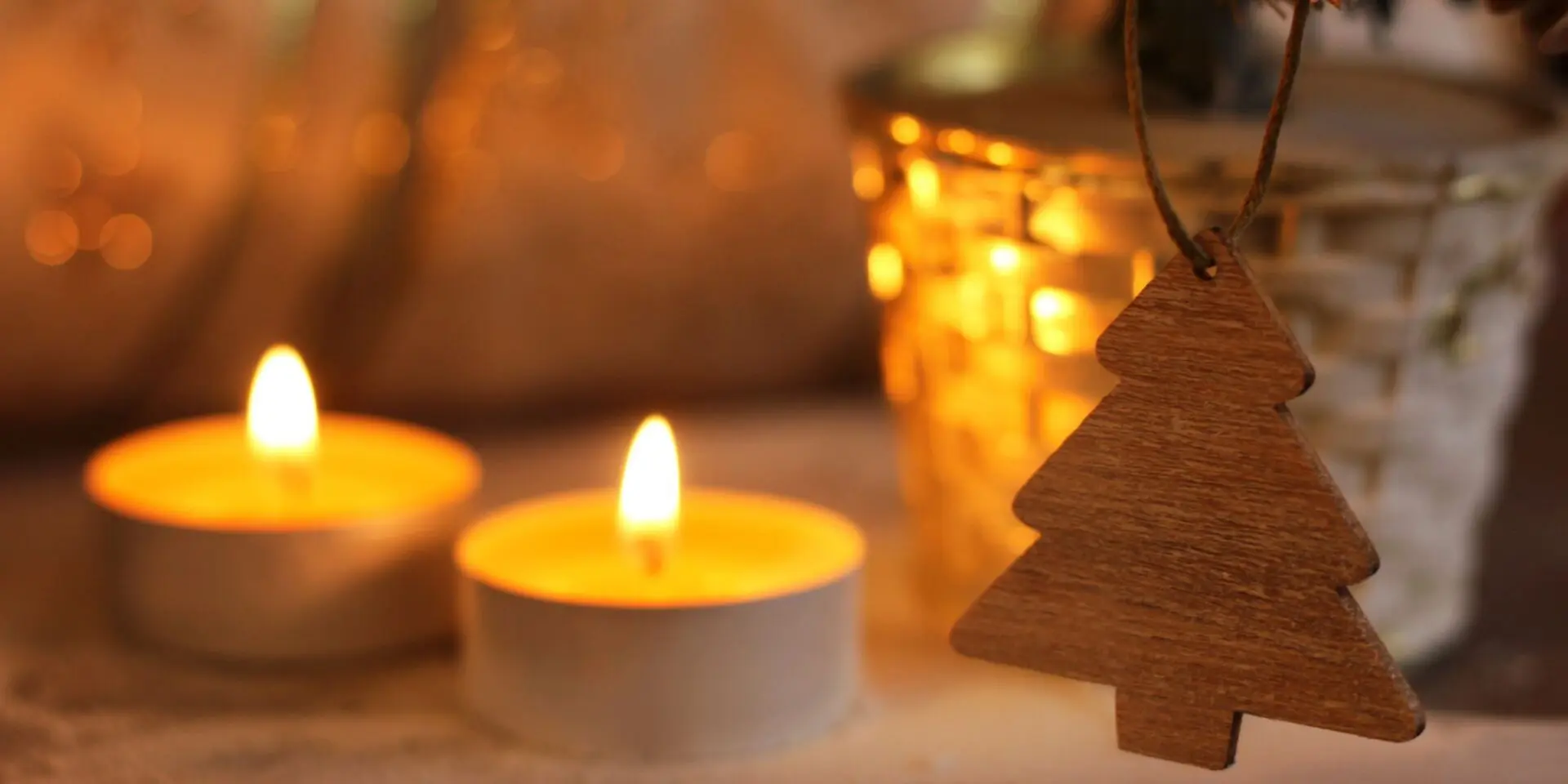 Two candles behind a tree shaped Christmas decoration - Winston's Wish