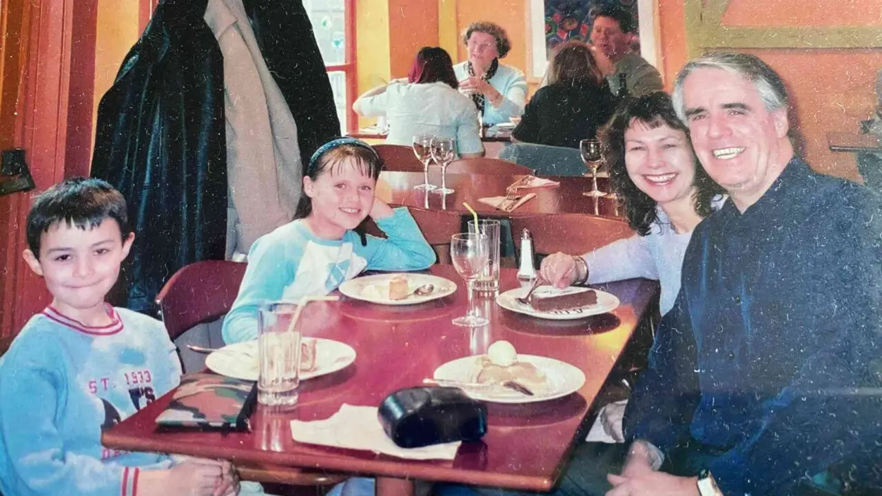 Family photo of Jane, Chris and their children at a dinner table