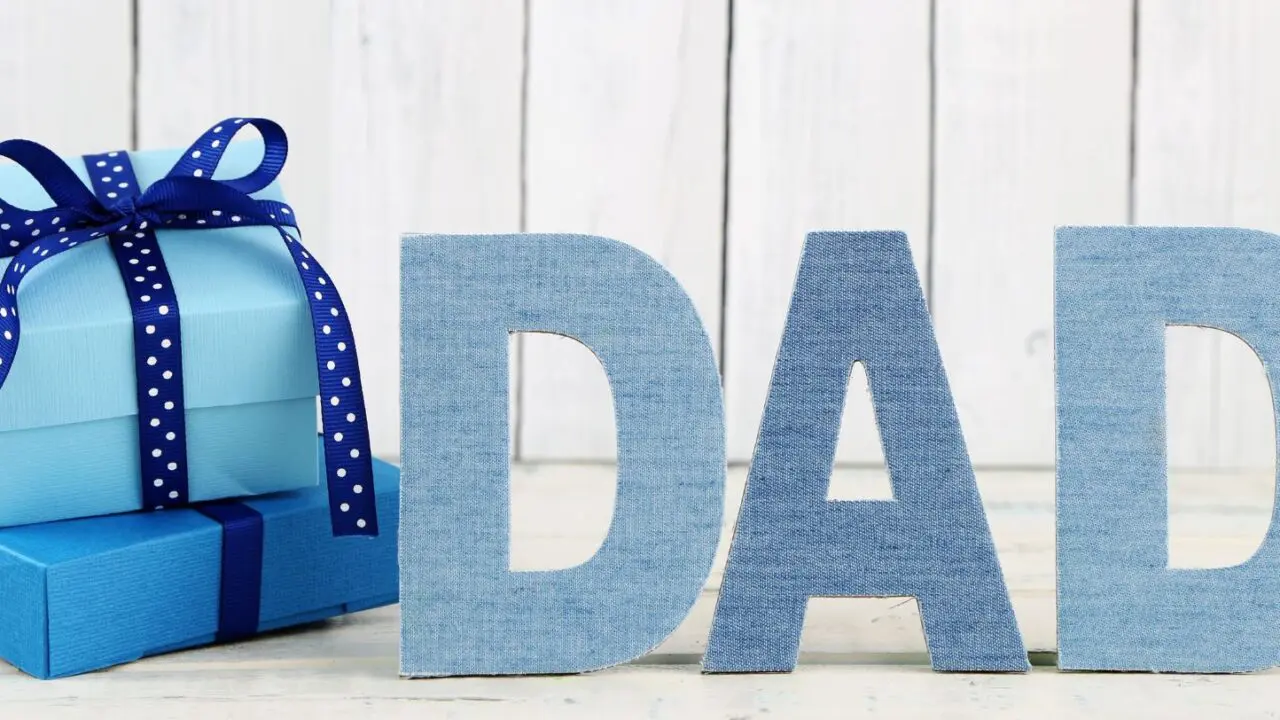 Father's Day image with the word Dad displayed next to presents on a neutral background