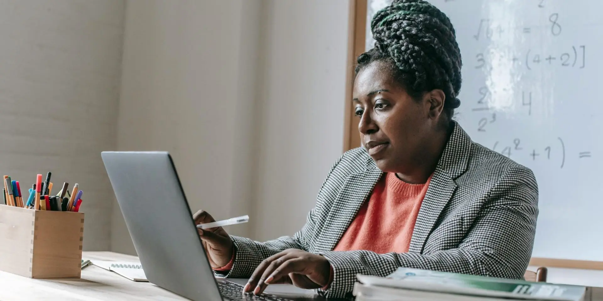 Woman sat at laptop in a school classroom - free webinar