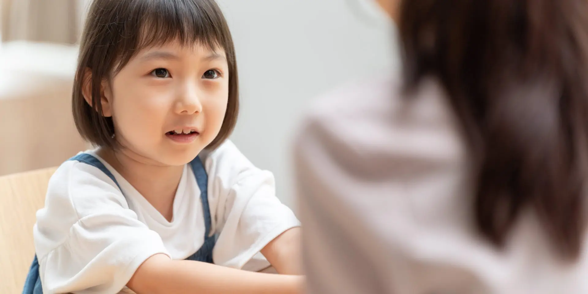 Young Asian child looking at parent.