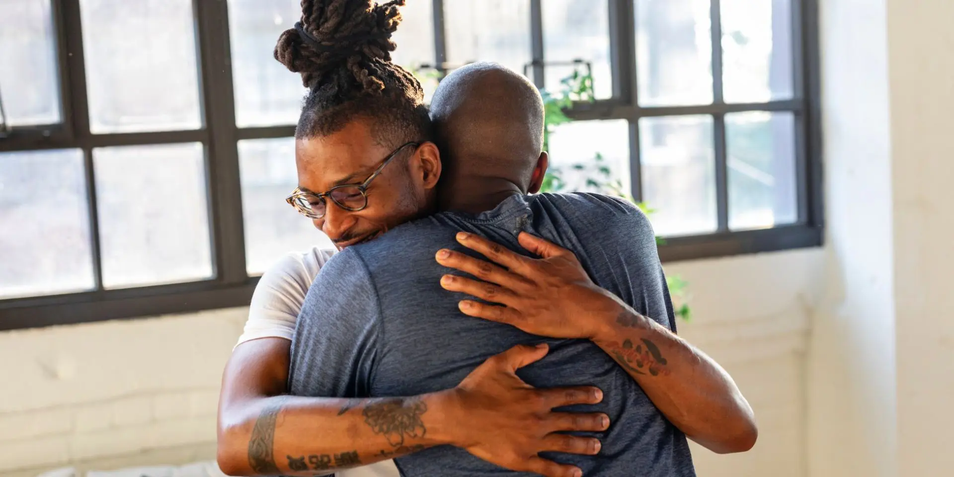 Two men hugging in a loft style apartment - parent mental health day, WAY, Widowed and Young