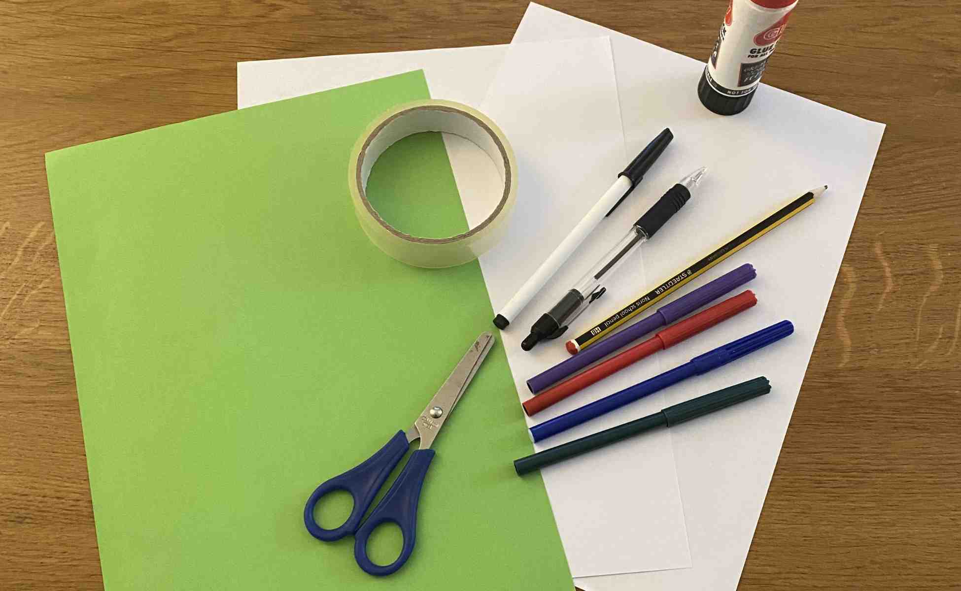 Photo of the materials you need for the Thankful Tree activity - green and white A4 paper, pens, scissors, tape and glue