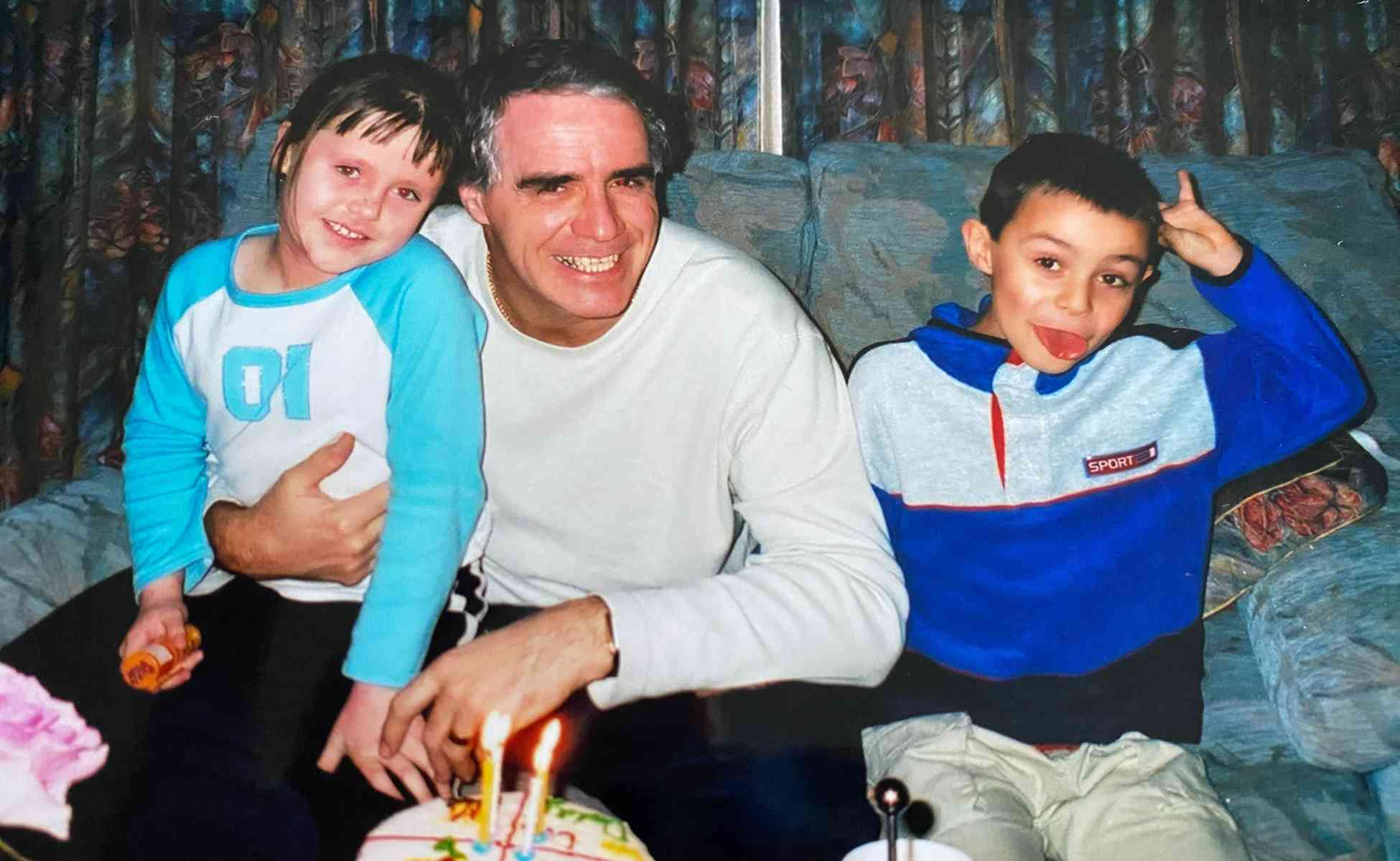 Chris and his children blowing out candles on a birthday cake