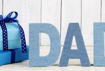 Father's Day image with the word Dad displayed next to presents on a neutral background