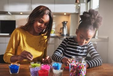 Woman with young child doing crafts together - navigating anniversaries, birthdays and special days